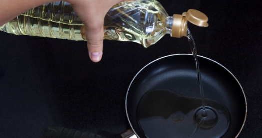 oil being poured into frying pan