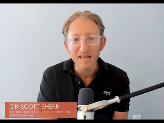 Scott Sherr seated at table with microphone.