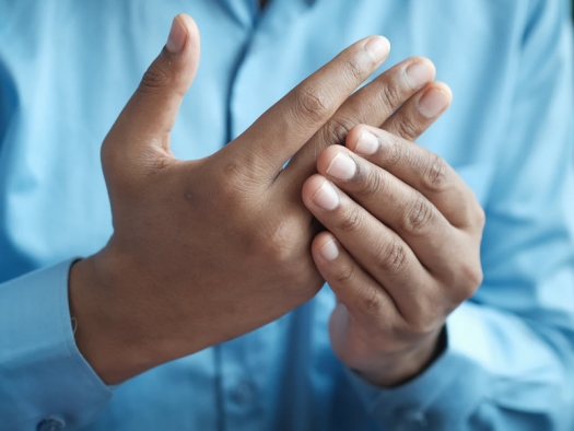 man in blue shirt holding and rubbing his hands in front of him