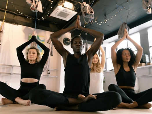 Group seated on floor, stretching in yoga class